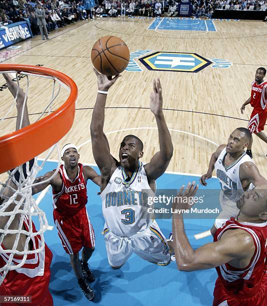 Chris Paul of the New Orleans/Oklahoma City Hornets shoots a jumper against Juwan Howard and Rafer Alston of the Houston Rockets during a game on...