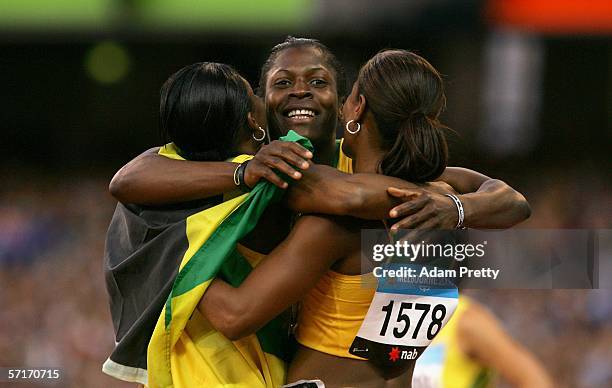 Brigitte Foster-Hylton of Jamaica celebrates with her teammates Delloreen Ennis-London and Lacena Golding-Clarke after Foster-Hylton won the women's...