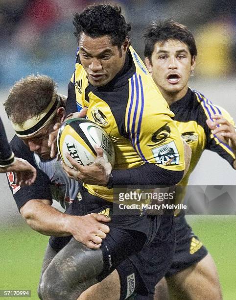 Lome Fa'atau of the Hurricanes gets tackled by Brendon Botha of the Sharks during the round seven Super 14 match between the Hurricanes and the...