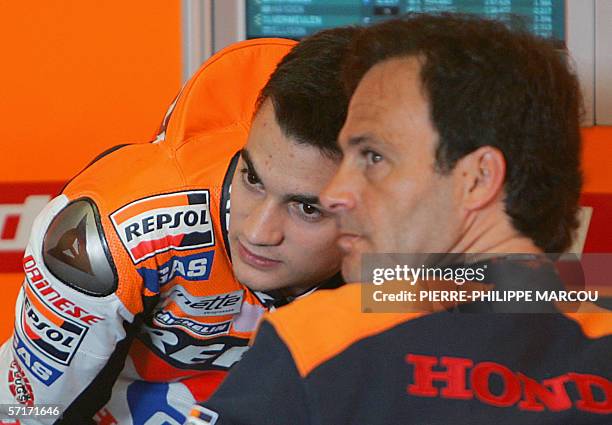 Spain's Honda Moto Grand Prix rider Dani Pedrosa chats with team's coach Alberto Puig in Jerez, 24 March 2006 during the first free practice session...