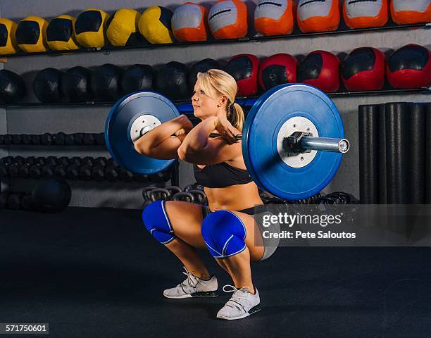 young woman squatting with barbell in gym - kneepad stock pictures, royalty-free photos & images