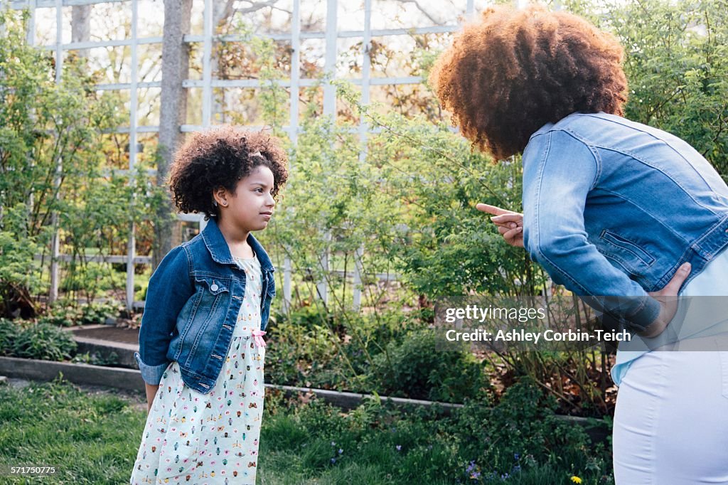 Mother scolding girl, hand on hip, pointing finger