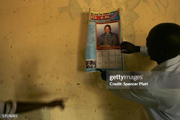 People hang a poster for presidential candidate Mbusa Nyamwisi at a campaign office March 24, 2006 in Bunia, Congo. The Democratic Republic of Congo...