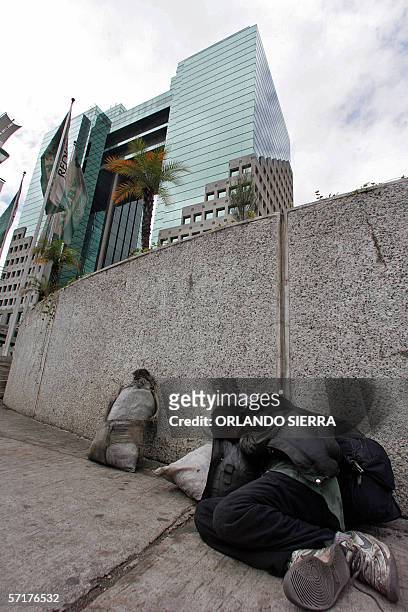 Un indigente duerme en una acera frente a un moderno hotel de Ciudad de Guatemala, el 24 de marzo de 2006. El gobierno del presidente Oscar Berger...