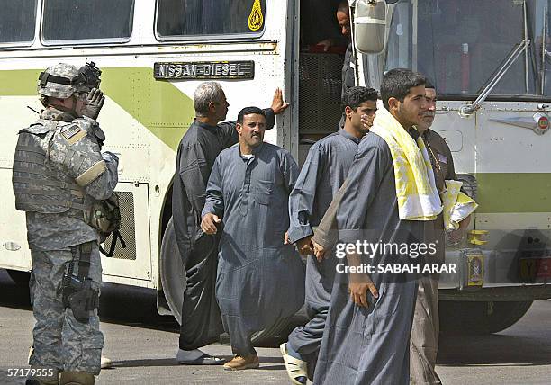 Soldier guides freed Iraqi prisoners after they were released from Abu Ghraib prison in Baghdad, 25 March 2006. Some 4,500 are held in the US-...