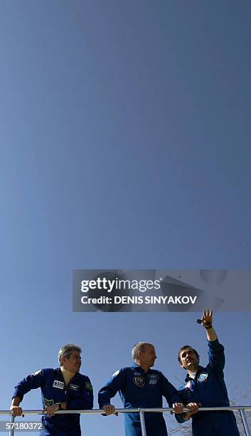 Russian cosmonaut Pavel Vinogradov points to the sky next to US astronaut Jeffrey Williams and Brazilian astronaut Marcos Pontes during their walk at...