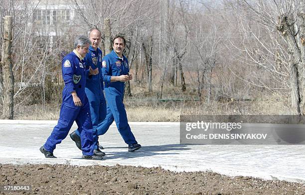 Russian cosmonaut Pavel Vinogradov , US astronaut Jeffrey Williams and Brazilian astronaut Marcos Pontes take a walk outside their base in the town...