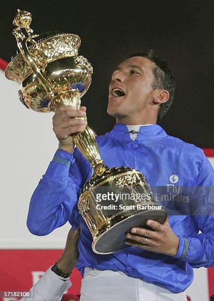 Jockey Frankie Dettori celebrates with the trophy after riding Electrocutionist to win race 7 the Dubai World Cup during the 2006 Dubai World Cup...