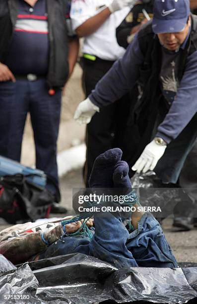 Fiscales del Ministerio Publico proceden a identificar el cadaver de un hombre, encontrado maniatado, con el tiro de gracia y envuelto en nylon, en...