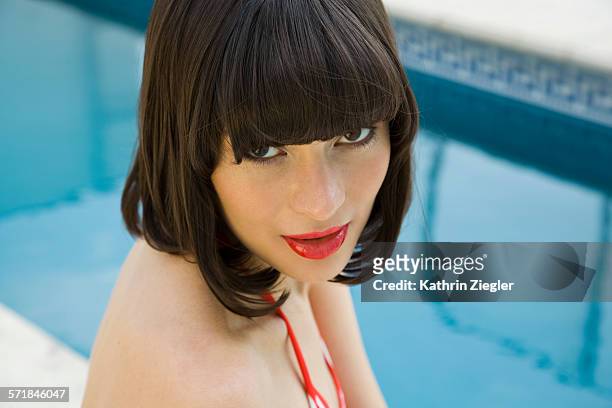 portrait of beautiful young woman at swimming pool - frangia foto e immagini stock