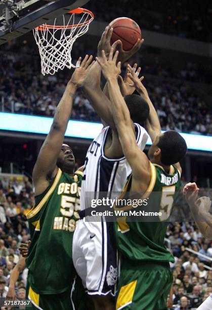 Rudy Gay of the Connecticut Huskies shoots over the defense of Jai Lewis and Gabe Norwood of the George Mason Patriots during the Regional Finals of...