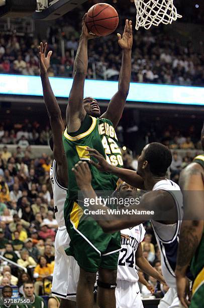Folarin Campbell of the George Mason Patriots lshoots over the defense of the Connecticut Huskies during the Regional Finals of the NCAA Men's...