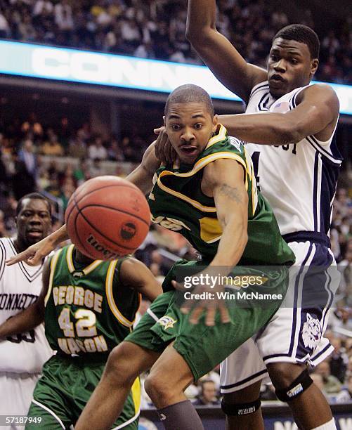 Lamar Butler of the George Mason Patriots vies for the ball with Connecticut's Jeff Adrien during fourth quarter action against Connecticut during...