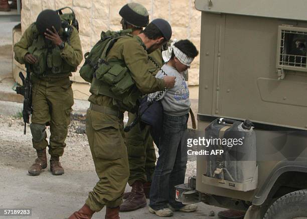 Nael al-Atrash, eleven-years-old, is blind folded and hand cuffed by Israeli soldiers who raided the neighborhood of Jabal al-Takruri in the West...