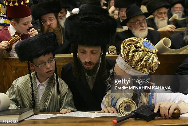Child listens on as Ultra Orthodox Jews from the Wiznitz Hassidim group reads the Ester scrolls at the synagogue in the Israeli town of Beni Brak...