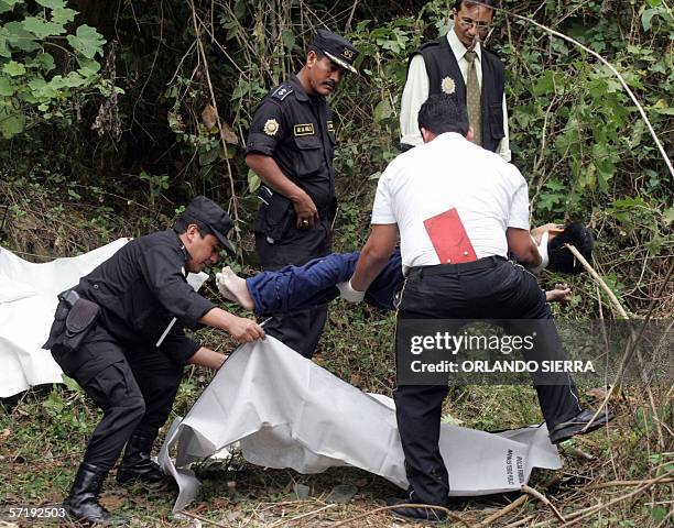 Miembros del Cuerpo de Bomberos Voluntarios, fiscales del Ministerio Publico y agentes de la Policia Nacional Civil levantan el cadaver de un...