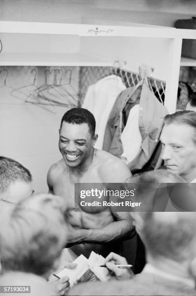 American baseball player Willie Mays of the San Francisco Giants sits shirtless in the locker room and laughs as he answers questions following his...