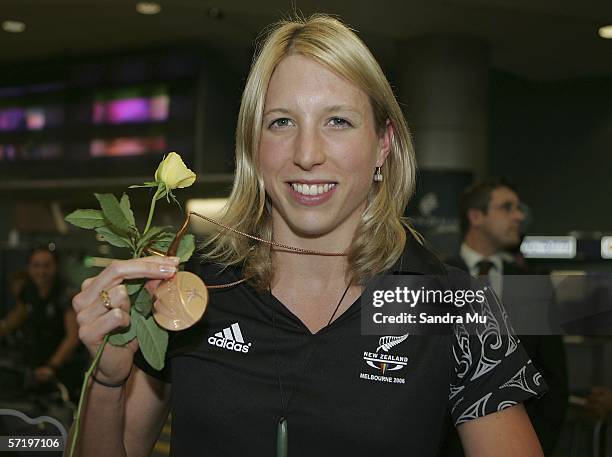 Swimming bronze medalist Hannah McLean poses with her medal upon her arrival with the New Zealand athletes from the Commonwealth Games at Auckland...