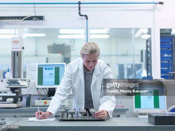 female engineer inspecting artificial hip joint parts in quality control department in orthopaedic factory - hip replacement stock pictures, royalty-free photos & images