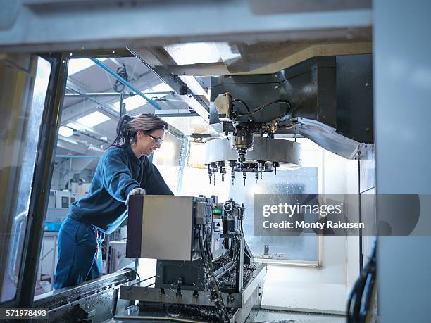 female apprentice engineer setting up cnc lathe in engineering factory - cnc stock pictures, royalty-free photos & images