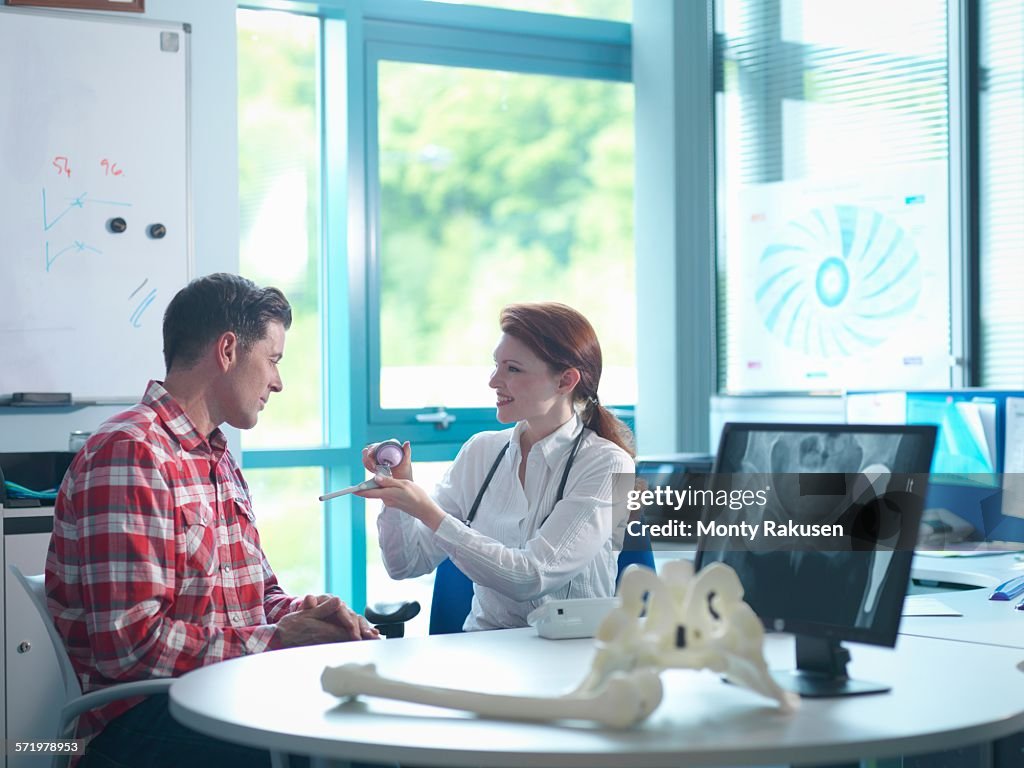 Female orthopaedic consultant with patient in consulting room