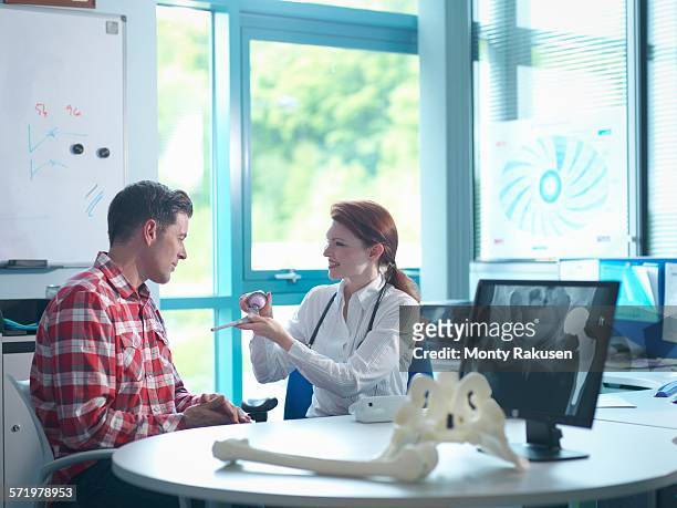 female orthopaedic consultant with patient in consulting room - hip replacement stock pictures, royalty-free photos & images