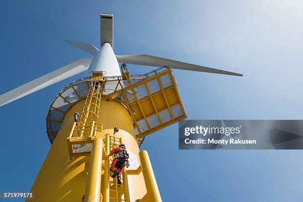 engineers climbing wind turbine from boat at offshore windfarm, low angle view - turbine 個照片及圖片檔