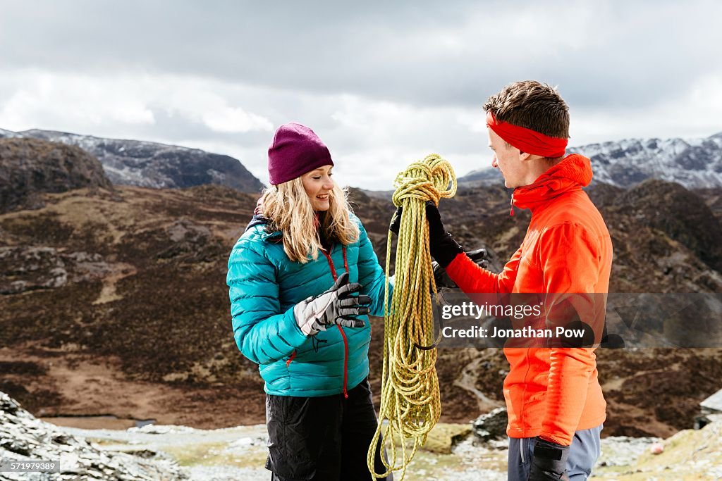 Young couple hiking, holding safety rope, Honister Slate Mine, Keswick, Lake District, Cumbria, United Kingdom