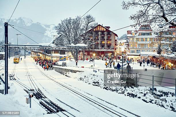 crowds of passengers at snow covered train station, wengen, switzerland - wengen stock pictures, royalty-free photos & images