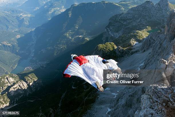 two male base jumpers wingsuit flying from mountain, dolomites, italy - wing suit stock pictures, royalty-free photos & images