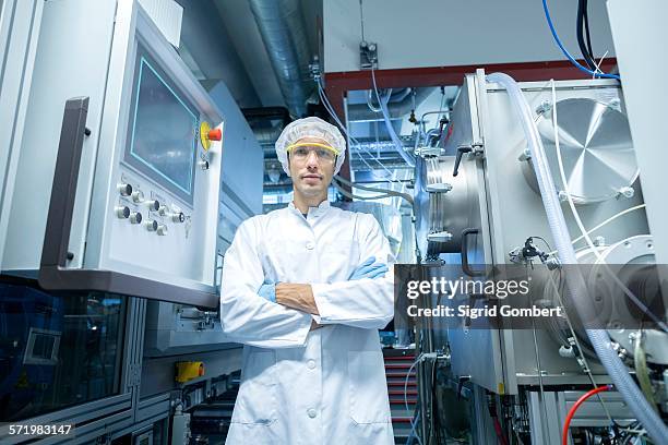 portrait of male scientist with arms folded in lab cleanroom - cleanroom stock-fotos und bilder