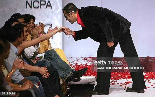 Indian actor Salman Khan kisses the hand of fellow actress Priety Zinta seated among the audience at a show by Indian designer Surily Goel on the...