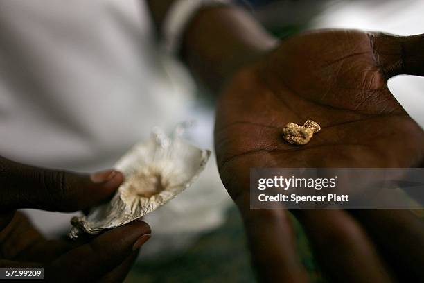 Gold buyer displays a recent purchase March 28, 2006 in the gold mining town of Mongbwalu, Congo. Thousands of Congolese scrape together meager...