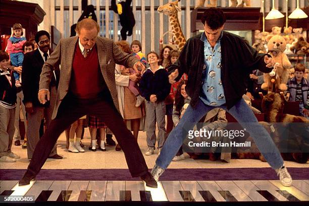 Film still shows American actors Robert Loggia and Tom Hanks on a giant keyboard at the FAO Schwartz toy store in the film 'Big' , 1988.