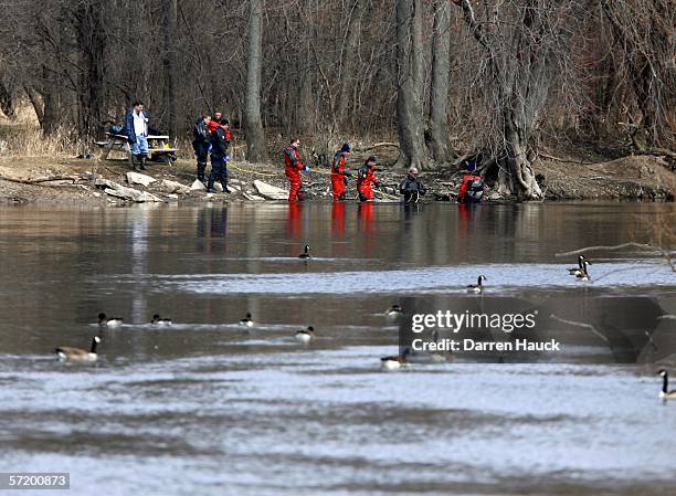 Members of the Milwaukee police department dive team prepare to wade through water along the banks of the Milwaukee River in search for missing boys,...