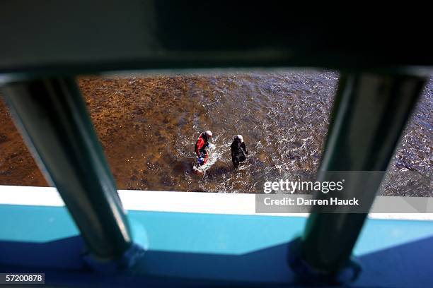 Members of the Milwaukee police department dive team wade through water along the banks of the Milwaukee River in search for missing boys, Quadrevion...