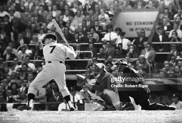 American baseball player Mickey Mantle of the New York Yankees continues to swing at bat in spite of leg pain during the World Series against the...