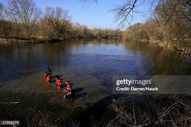 Members of the Milwaukee police department dive team wade through water along the banks of the Milwaukee River in search for missing boys, Quadrevion...