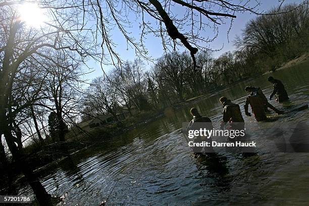 Members of the Milwaukee police department dive team wade through water along the banks of the Milwaukee River in search for missing boys, Quadrevion...