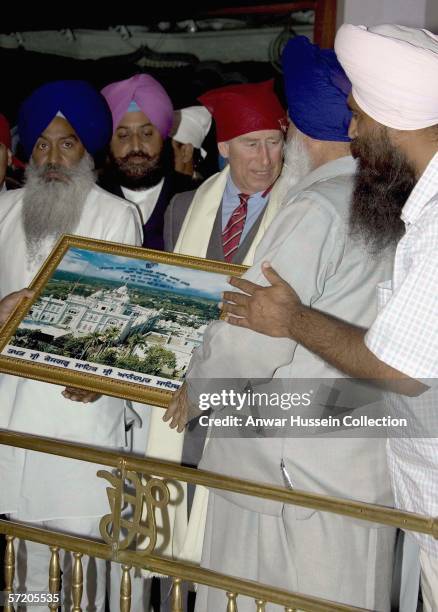 Prince Charles, Prince of Wales receives a picture of the Gurdwara as he visits the Anadpur Sahib Gurdwara on the eighth day of a 12 day official...