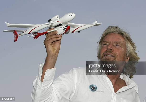 Sir Richard Branson poses a model of 'Spaceship One' after a Press conference for Virgins new service Virgin Galactic at Emirates Towers on March 29,...