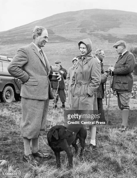 Queen Elizabeth II chats to winner Douglas Walker after presenting him with the Challenge Cup at the finish of the two-day Retriever Trials at...