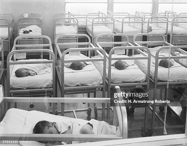 1960s: Newborn baby cribs in hospital nursery.