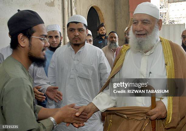 The former Imam of Palestinian Mosque Aqsa, Shiekh Ahmed Mahmood Siyam shakes hands with a student of The Jamia Binoria Islamic University during his...