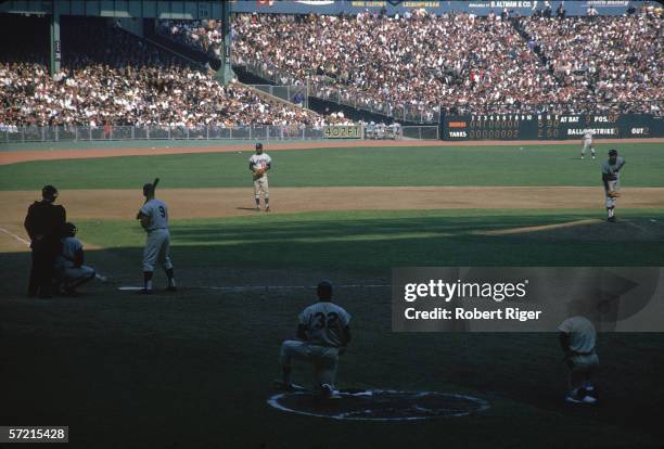 American baseball player Roger Maris third from left), right fielder of the New York Yankees, stands at home plate ready for a pitch from Sandy...