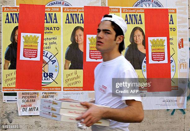 Pizza's delivery man passes by electoral posters, in Naples 30 March 2006, 10 days before the Italian general elections. The last opinion polls...