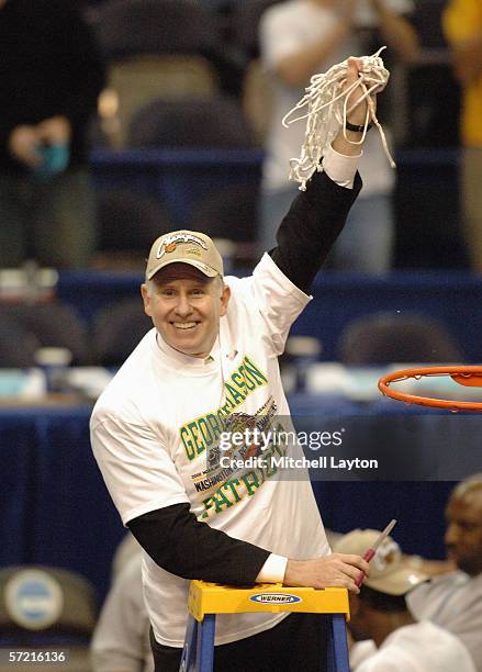Head coach Jim Larranaga of the George Mason Patriots cuts down the nets following the game against the Connecticut Huskies in the Regional Finals of...
