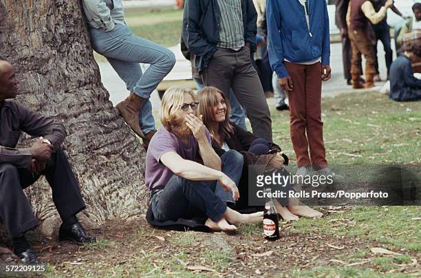 View of hippies and young people standing and sitting in a park in the Haight-Ashbury district of San Francisco during the 'Summer of Love' in 1967....