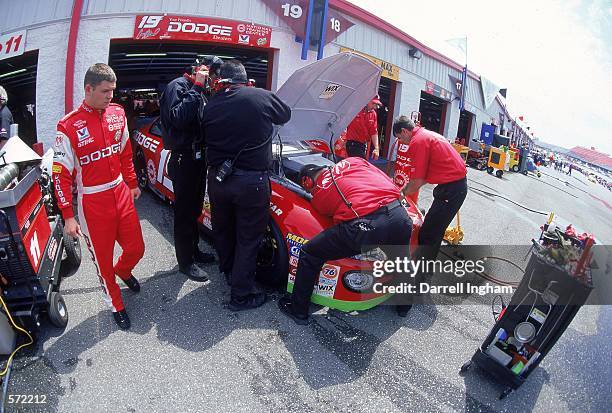 Casey Atwood who drives the Dodge Intrepid for Evernahm Motorsports walks to his car as his crew fixes the engine during the Talladega 500 presented...