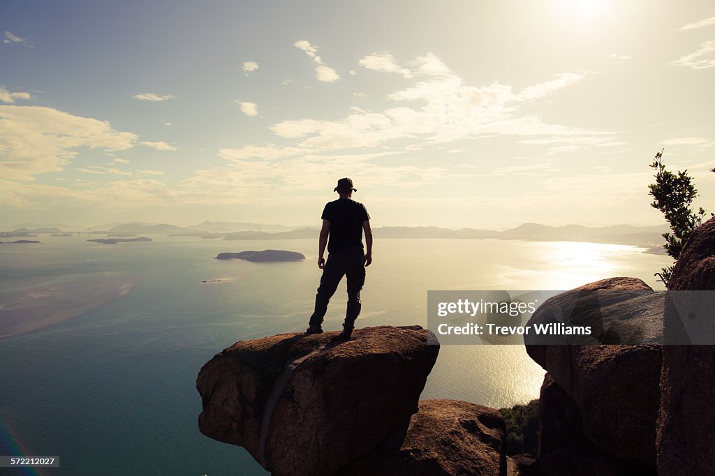 A man watching the sun set from a mountain top